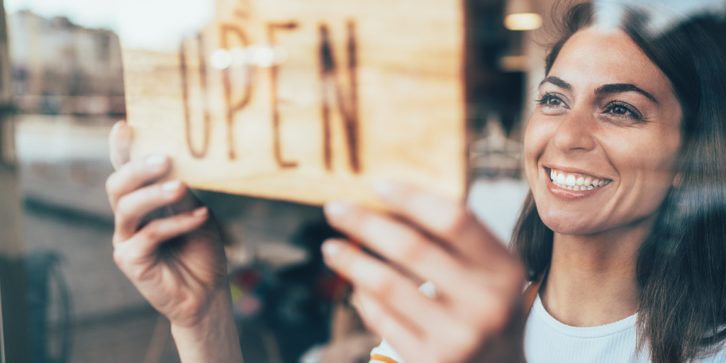 small business owner holding up an open sign